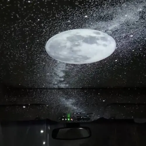 Una gran luna y estrellas proyectadas en un techo blanco